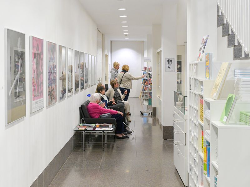 Der Museumsshop mit aufgehängten Plakaten links und einem Verkaufsregal, sowie einer Verkaufsvitrine rechts